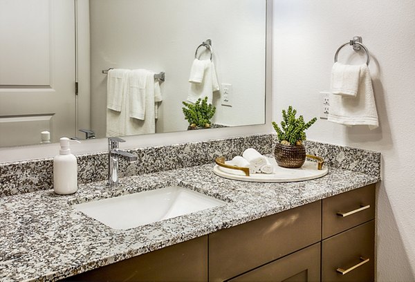 Bathroom featuring modern fixtures and dual sinks at Ascend at Prairie Village Apartments