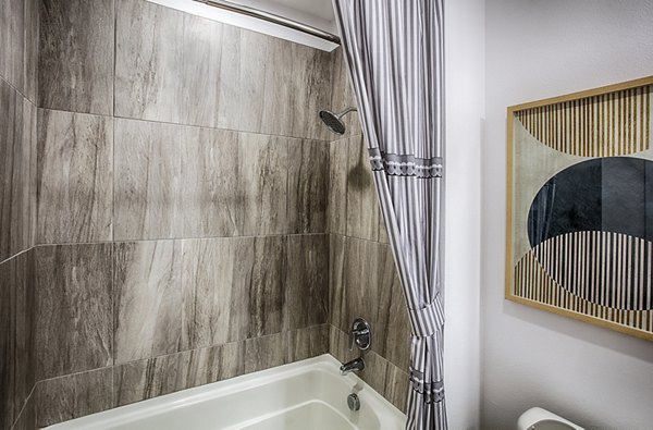 Bathroom featuring modern fixtures and granite countertops in Ascend at Prairie Village Apartments