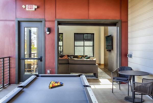Modern game room featuring pool table and lounge seating at Ascend at Prairie Village Apartments