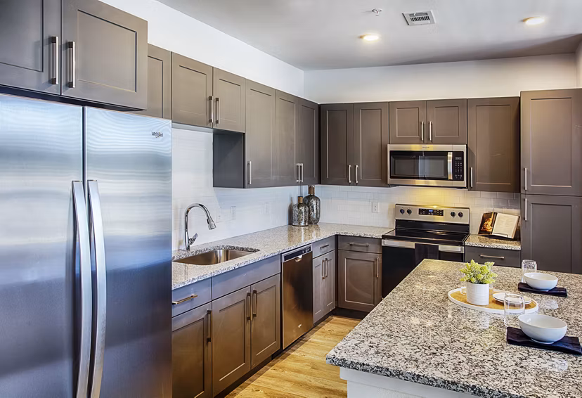 Modern kitchen with stainless steel appliances at Ascend at Prairie Village Apartments