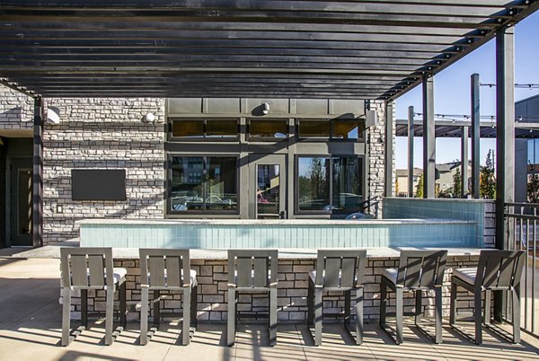 Outdoor grill area with modern seating at Ascend at Prairie Village Apartments, ideal for social gatherings and BBQs