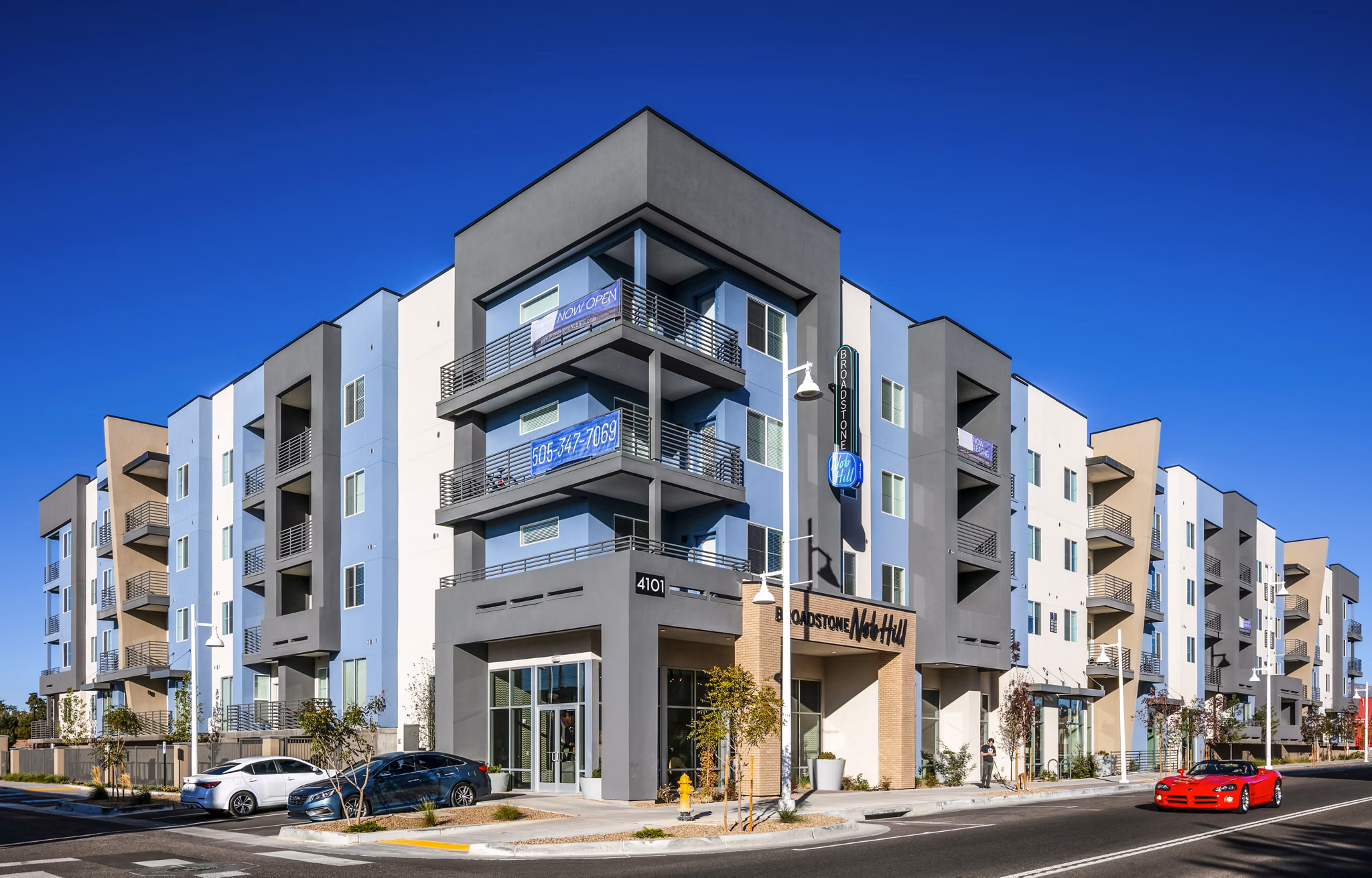 Modern luxury apartment building with multiple floors and balconies in an urban setting