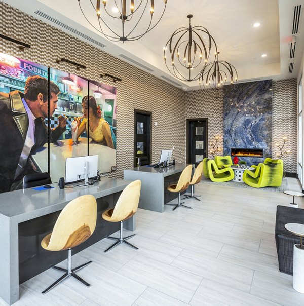 Modern office reception area with desks, chairs, decorative lighting, and artwork on the wall