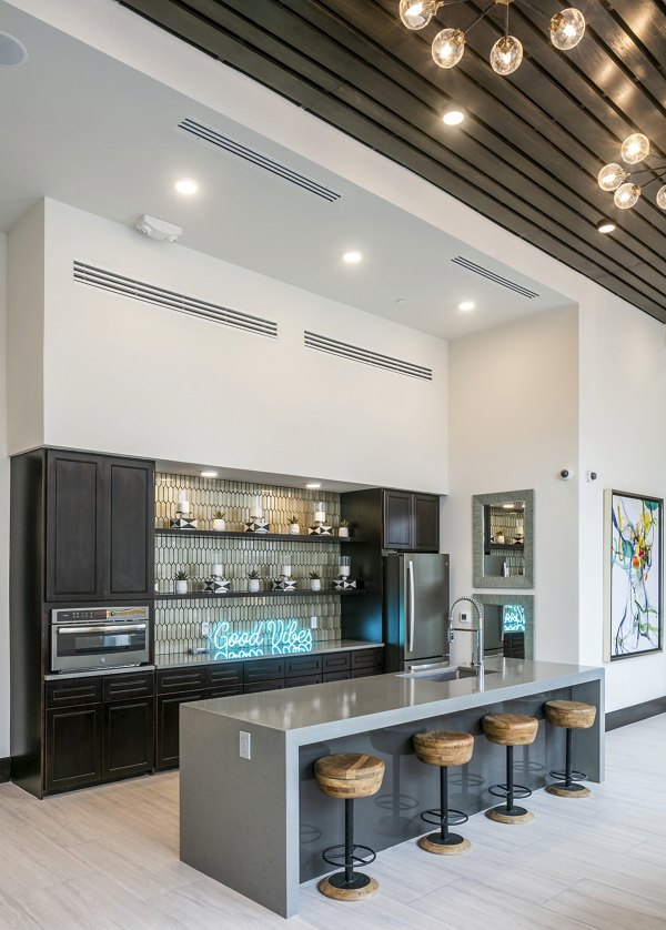Modern kitchen featuring a large island and dark cabinetry in luxury apartments