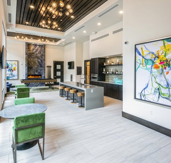 Stylish living area featuring cozy seating, a bar with stools, and abstract artwork in luxury apartments