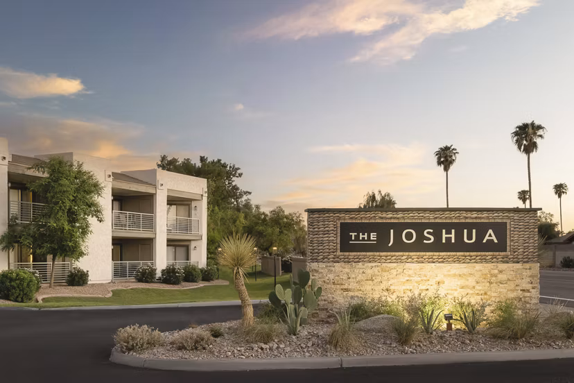The Joshua: Luxury apartment complex with palm trees and desert landscaping in a serene environment