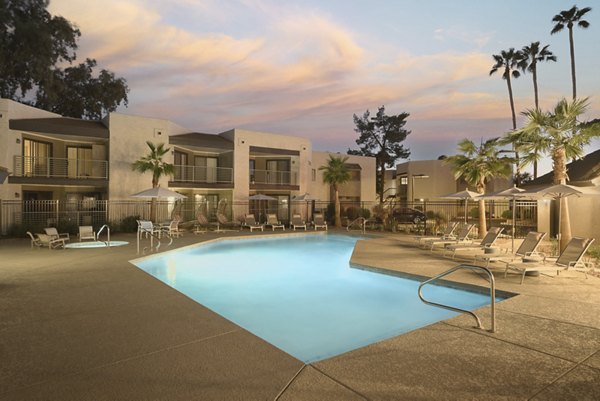 The Joshua Apartments: Outdoor pool with stylish loungers and lush landscaping