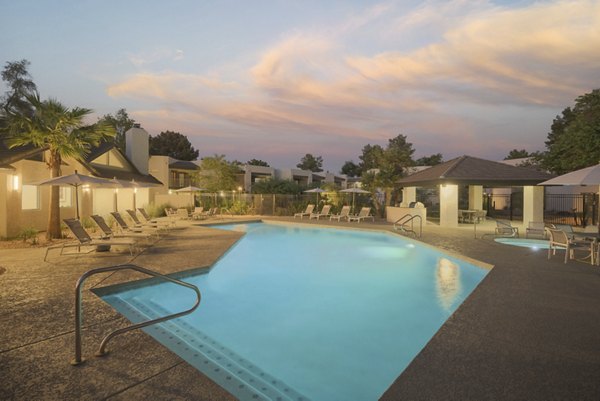 Expansive swimming pool with lounge chairs at The Joshua Apartments, offering luxury relaxation and recreation in a serene setting