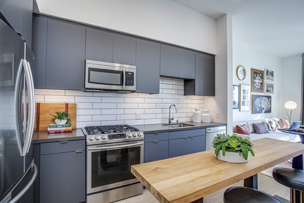 Modern kitchen with stainless steel appliances and quartz countertops in Oceanaire Apartments