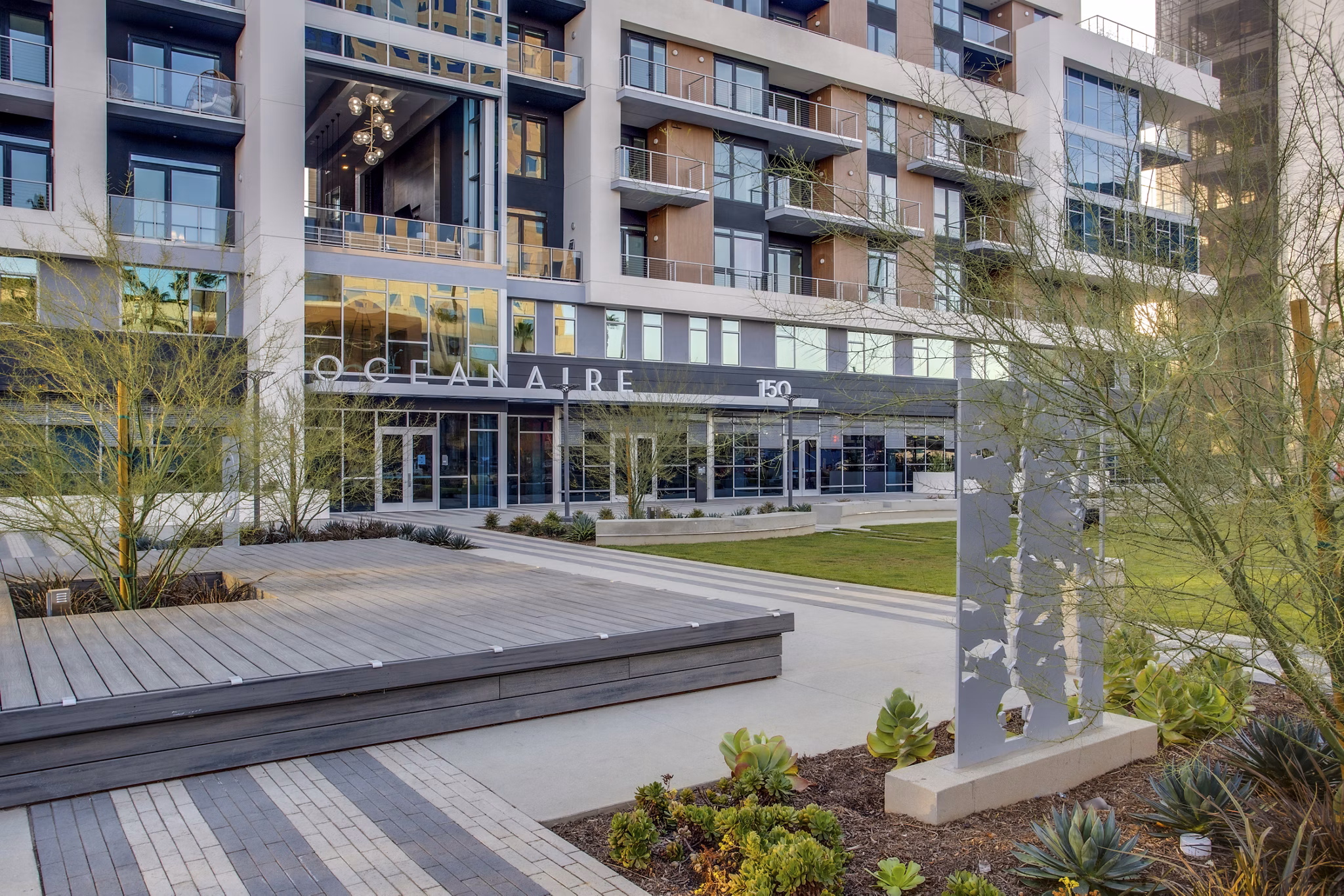 Oceanaire Apartments: Serene courtyard with lush landscaping in Greystar's luxury waterfront living community