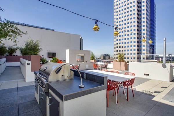 Modern outdoor grill area with seating at Oceanaire Apartments, offering luxury apartment living experience by Greystar