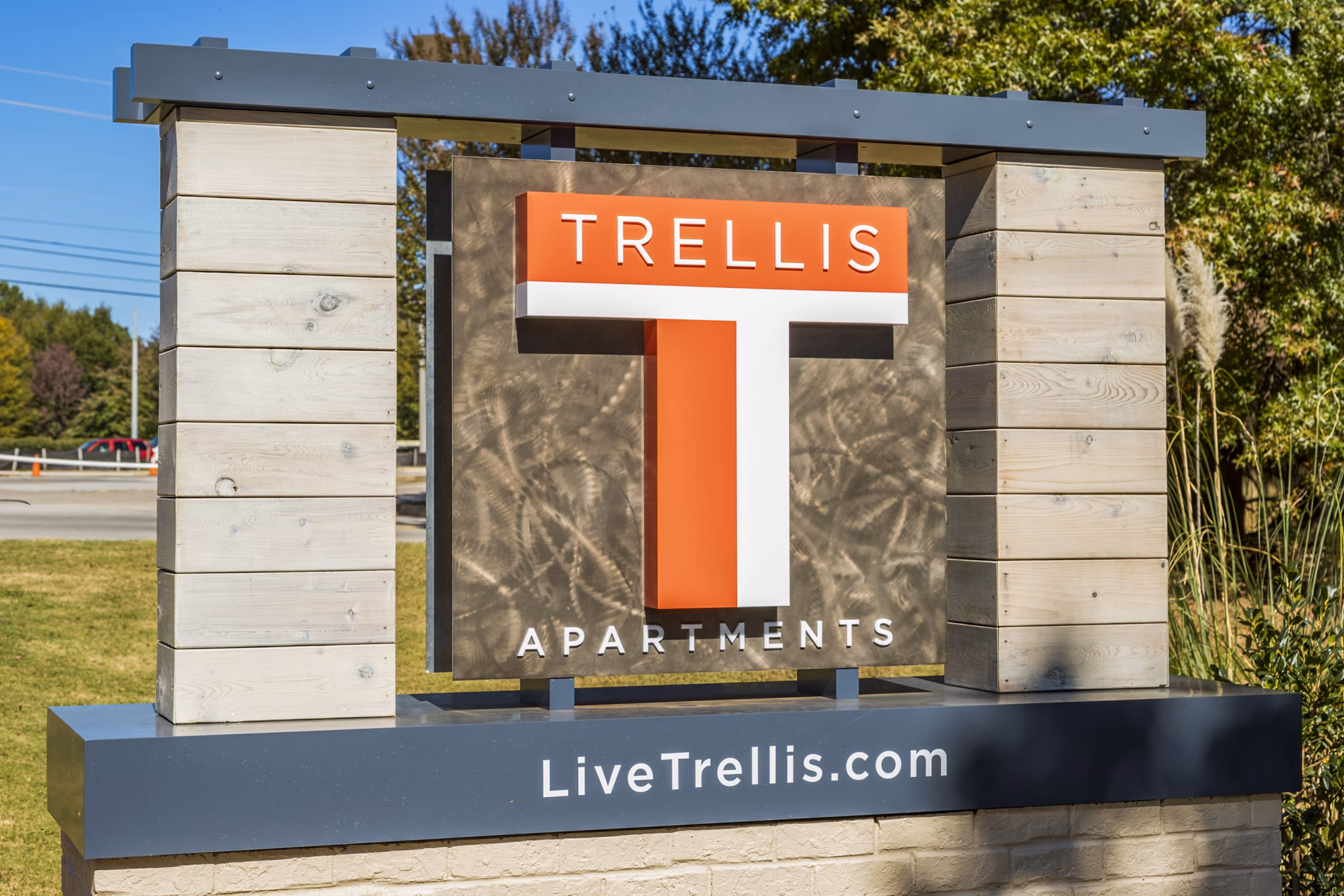Trellis Apartments: Welcoming sign featuring website LiveTrelliscom in a lush garden setting