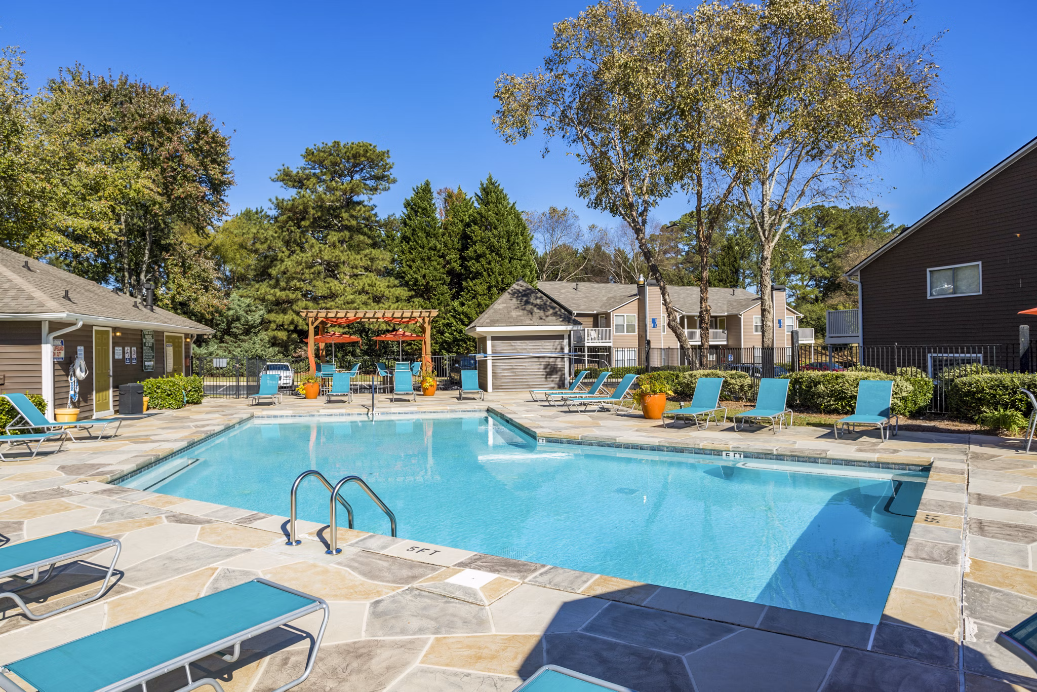 Luxury pool with sun loungers at Trellis Apartments, perfect for relaxation and leisure activities