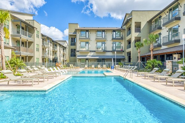 Resort-style pool at Citadel at Lookout Apartments with luxury features and surrounding palm trees