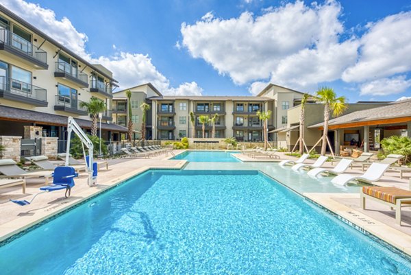 Outdoor pool with poolside seating at Citadel at Lookout Apartments