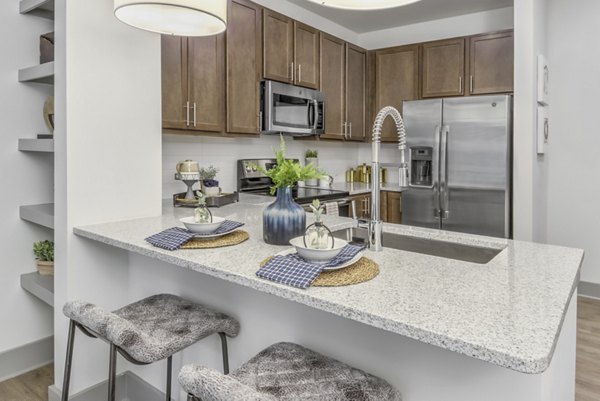 Modern kitchen with stainless steel appliances at Verde at McCullough Station Apartments