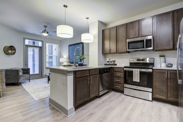 Modern kitchen with stainless steel appliances in Verde at McCullough Station Apartments