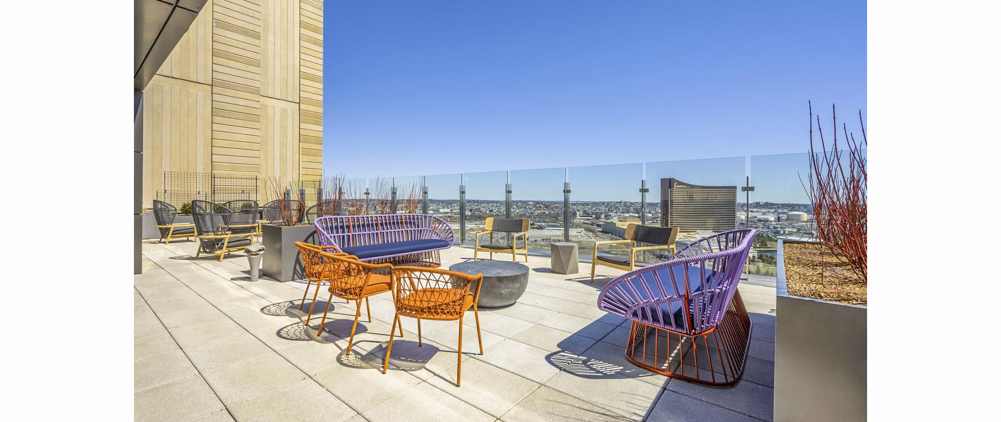 Private patio with stylish seating at Miscela Apartments, offering city views and relaxing outdoor space for residents