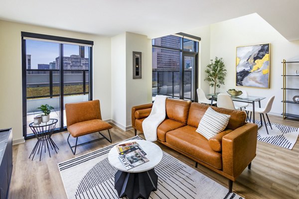 Cozy living room with modern furniture and city views at Ascent Peachtree Apartments