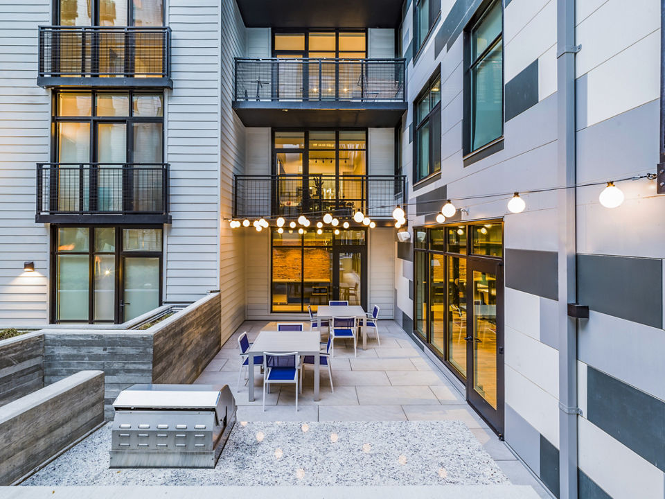 Grill area with modern BBQ stations and seating at Rowan Apartments, offering stylish outdoor dining experience