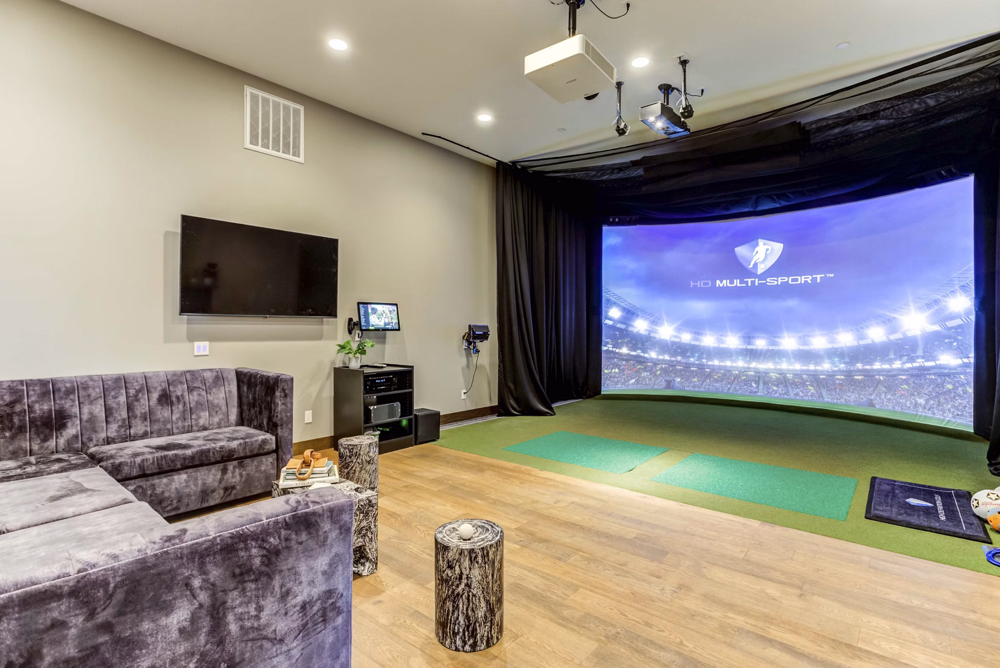 Theater room with plush seating and large screen at The Bower Apartments