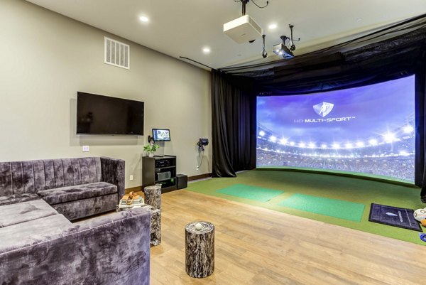 Theater room with plush seating and large screen at The Bower Apartments