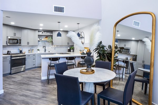 Elegant dining room featuring modern decor and large windows in Alexan Gallerie Apartments, ideal for luxury living experiences