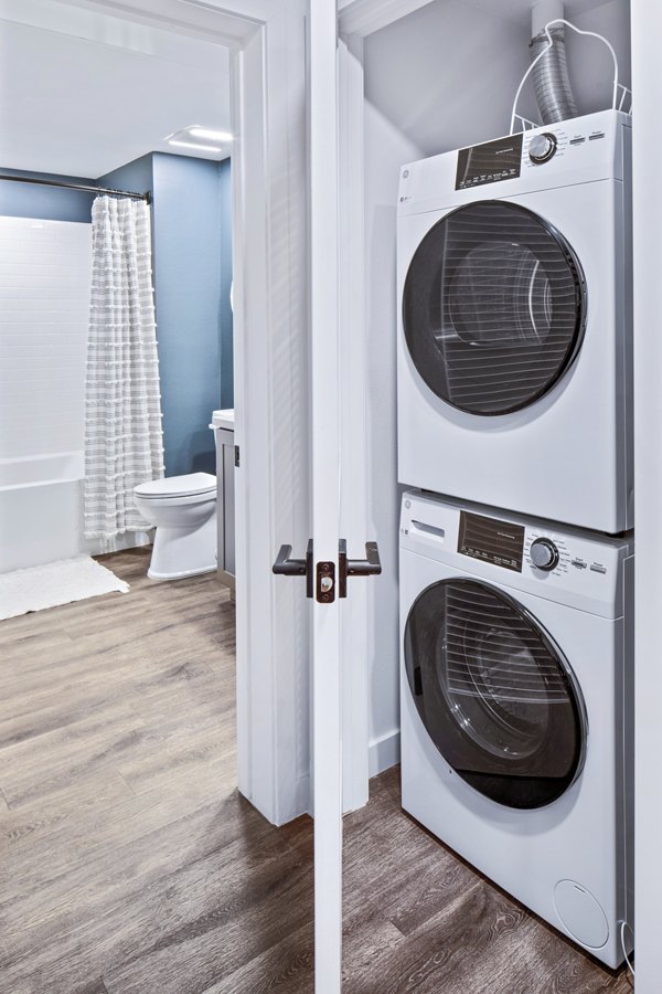 Modern laundry room with energy-efficient machines at Alexan Gallerie Apartments