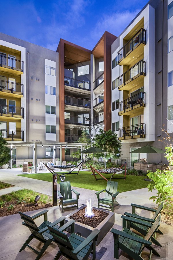 Outdoor fire pit and grill area at Alexan Gallerie Apartments, ideal for social gatherings and relaxation