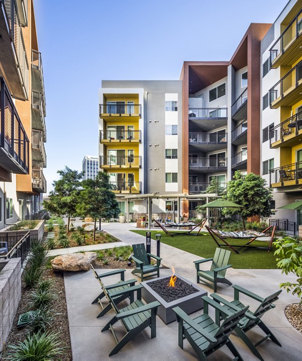 Fire pit and grill area at Alexan Gallerie Apartments, a Greystar luxury community Perfect for outdoor gatherings and leisure activities