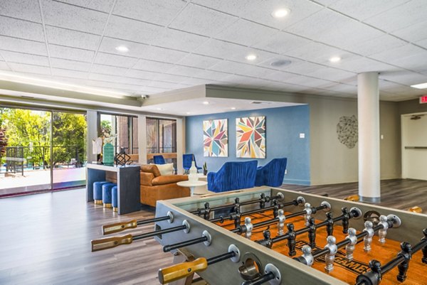 Clubhouse game room with billiards and lounge seating at Glo Apartments