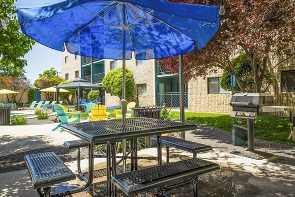 Grill area and patio with modern seating at Glo Apartments, perfect for outdoor gatherings in a luxury setting