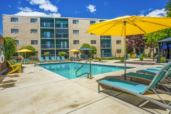 Relaxing pool area with lounge chairs at Glo Apartments, a luxury Greystar community offering urban living and leisure amenities