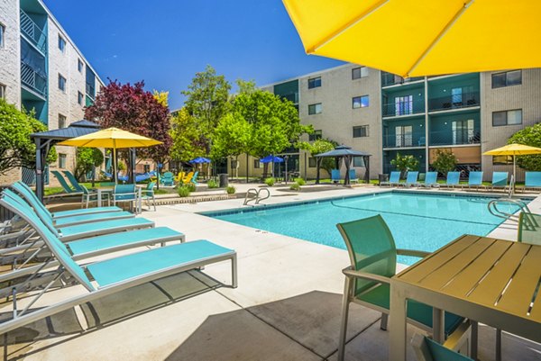 Luxurious pool with lounging area at Glo Apartments, perfect for relaxation and social gatherings