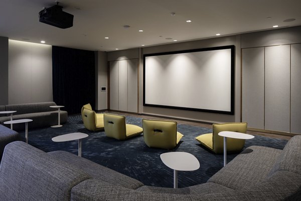 Modern theater room with plush seating and large screen at VOX Apartments, a Greystar luxury apartment community