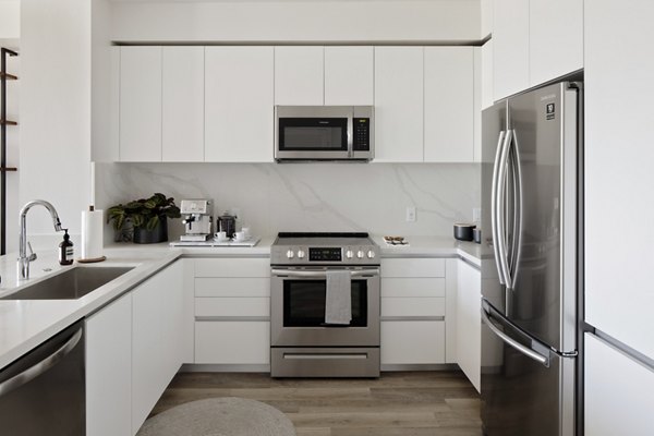 Modern kitchen with stainless steel appliances in VOX Apartments, a Greystar luxury apartment community