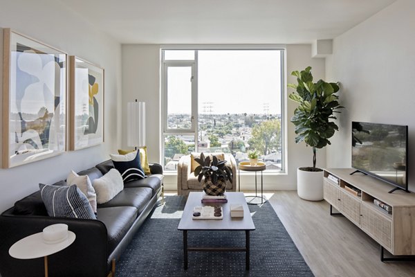 Modern living room with stylish furnishings and large windows in VOX Apartments