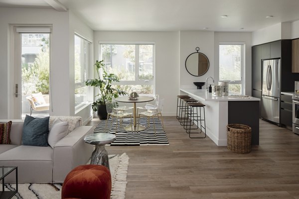 Modern living room with chic furnishings at VOX Apartments, featuring large windows and open layout in luxury apartments by Greystar