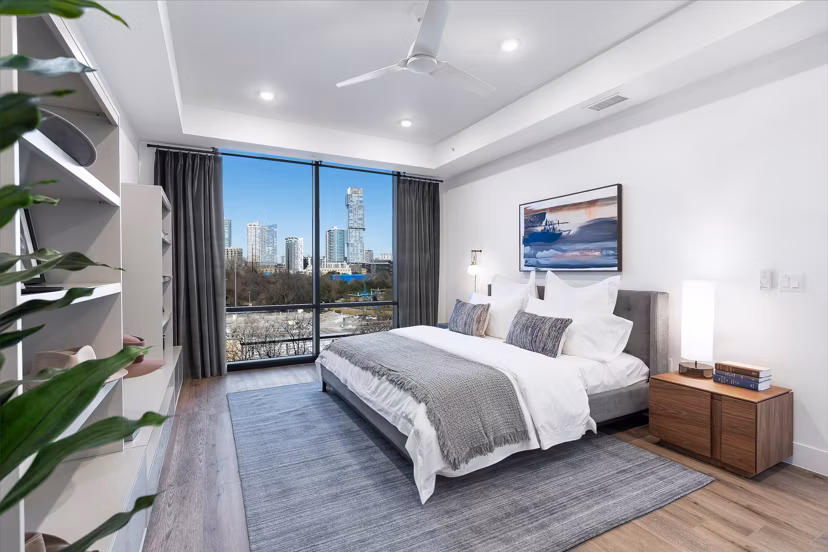 Luxury bedroom with elegant decor at 1155 Barton Springs Apartments, showcasing spacious layout and natural lighting