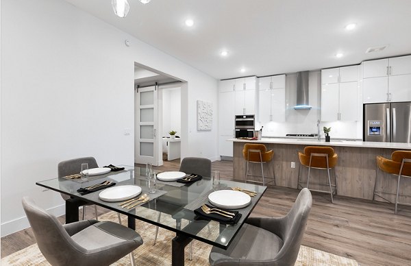 Dining area with modern furnishings and large windows at 1155 Barton Springs Apartments