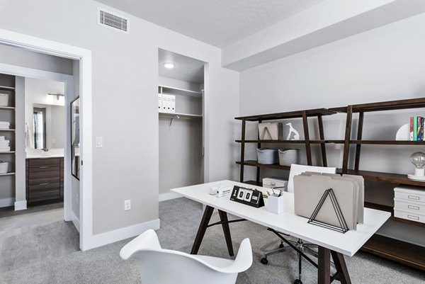 Cozy bedroom/office with modern design at The Lofts at Ten Mile Apartments, featuring workspace and stylish decor for luxury living experiences