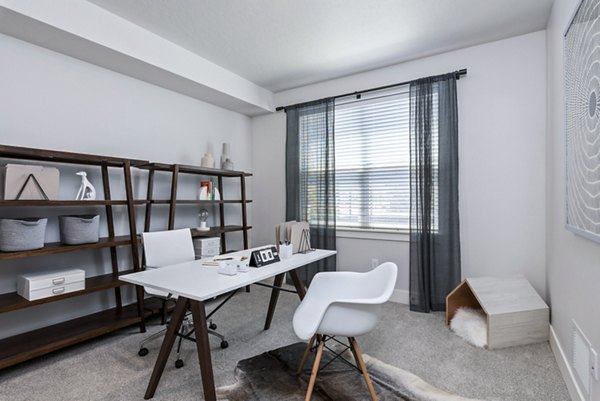 Cozy bedroom/office with natural light at The Lofts at Ten Mile Apartments, perfect for work-from-home comfort and convenience in luxury living