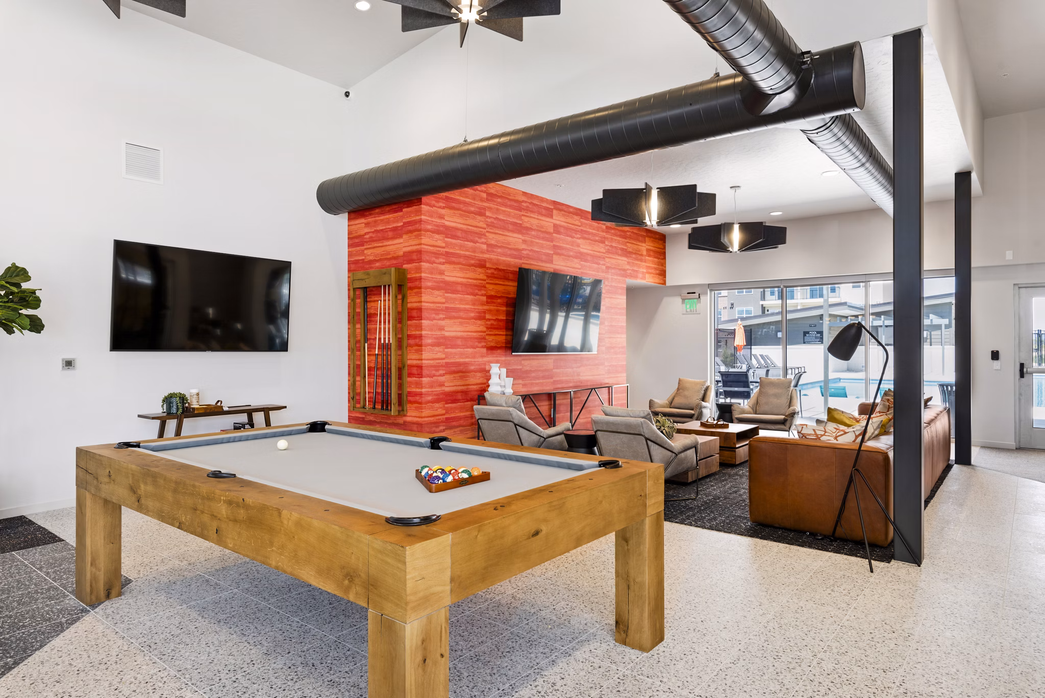 Game room with pool table and lounge chairs at The Lofts at Ten Mile Apartments