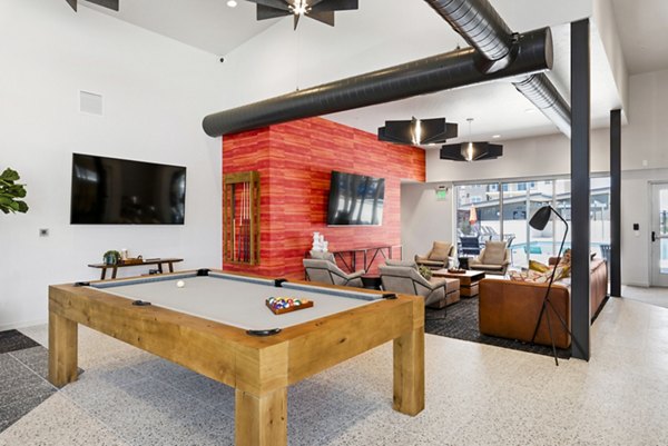 Game room with pool table and lounge chairs at The Lofts at Ten Mile Apartments