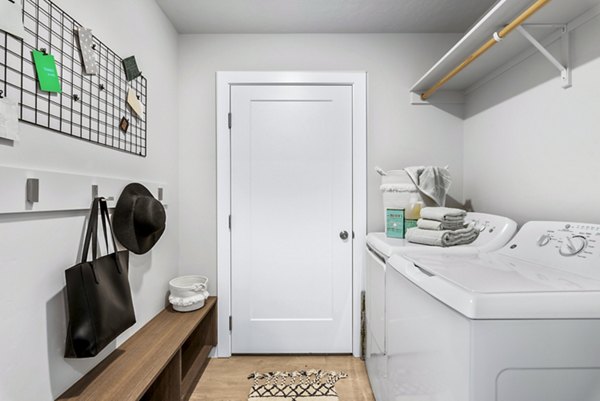 Laundry room with high-efficiency washers and ample folding space at The Lofts at Ten Mile Apartments