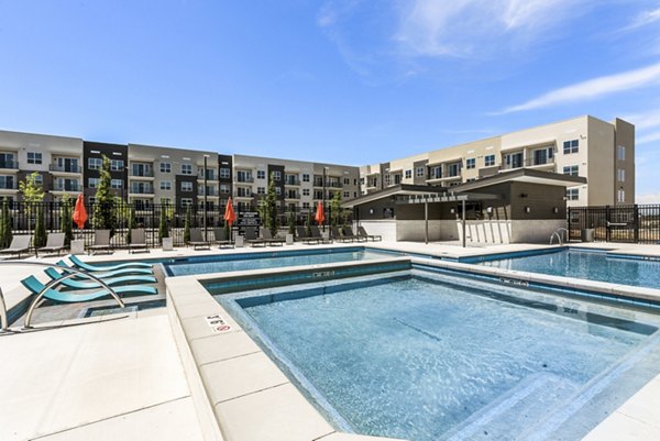 Luxury pool at The Lofts at Ten Mile Apartments, featuring sun loungers and modern design for relaxation