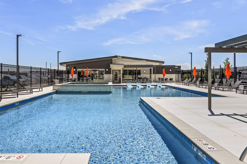 Relaxed poolside seating at The Lofts at Ten Mile Apartments, featuring a modern swimming pool area for residents to enjoy leisure time
