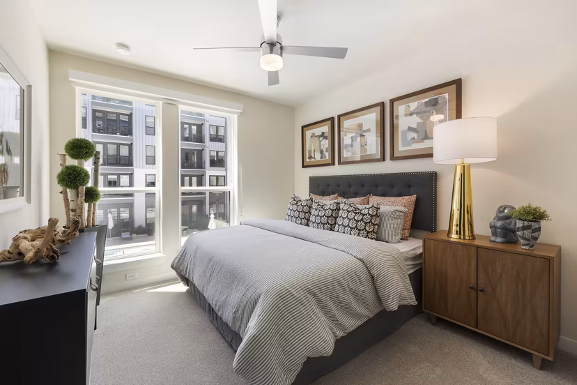 Modern bedroom with art dÃ©cor and large window at Art House Sawyer Yards Apartments in Houston