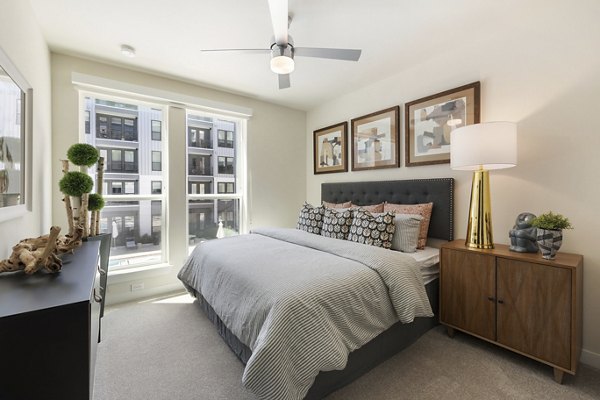 Modern bedroom with art dÃ©cor and large window at Art House Sawyer Yards Apartments in Houston