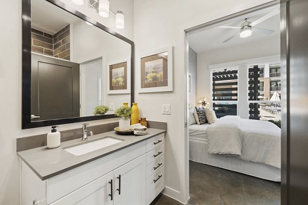 Compact bathroom with sleek fixtures at Art House Sawyer Yards Apartments, offering modern living with premium amenities in a vibrant community